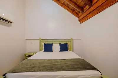 a bedroom with a large bed with blue pillows at La Dominica Hotel Boutique in Cartagena de Indias
