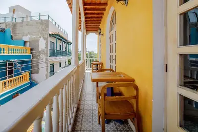 a balcony with a wooden table and chairs at La Dominica Hotel Boutique in Cartagena de Indias