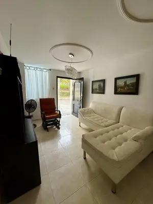 a living room with a white couch and a chair at First floor house in Barranquilla