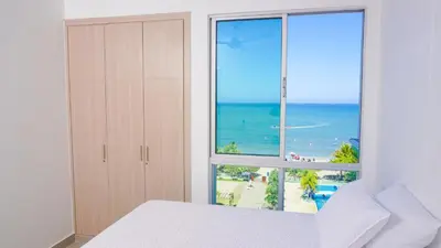 a bedroom with a large window with a view of the ocean at Magico Apartamento Frente al Mar 3 Habitaciones AR53 in Coveñas