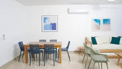 a dining room with a table and chairs and a couch at Magico Apartamento Frente al Mar 3 Habitaciones AR53 in Coveñas