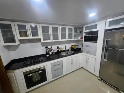 a kitchen with white cabinets and black counter tops at Guest House with AC, close to Historical Centre 1 in Cartagena de Indias