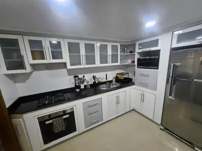 a kitchen with white cabinets and black counter tops at Guest house with AC close to Historical Centre 2 in Cartagena de Indias