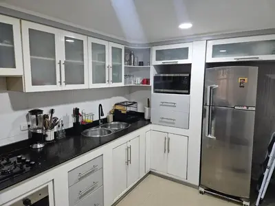 a kitchen with white cabinets and a stainless steel refrigerator at Guest house with AC close to Historical Centre 2 in Cartagena de Indias