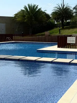 a large swimming pool with a fence and palm trees at Luxury Apartment betwen Cartagena and Barranquilla in Juan de Acosta