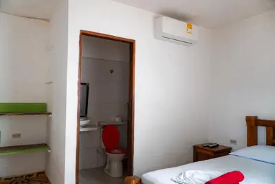 a room with a bed and a bathroom with a toilet at Cabaña las Palmas Rincon del Mar in Rincón