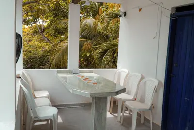a table and chairs on a patio with a window at Cabaña las Palmas Rincon del Mar in Rincón