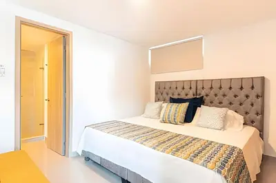 a bedroom with a large bed with a large headboard at Exclusivo Duplex @Cabrero con Piscina & Parking in Cartagena de Indias