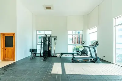 a gym with cardio equipment in a white room with windows at Exclusivo Duplex @Cabrero con Piscina & Parking in Cartagena de Indias