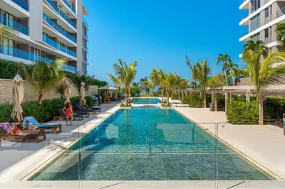 a swimming pool with palm trees and a building at Deluxe en MorrosEos con piscina privada y salida a la playa in Cartagena de Indias