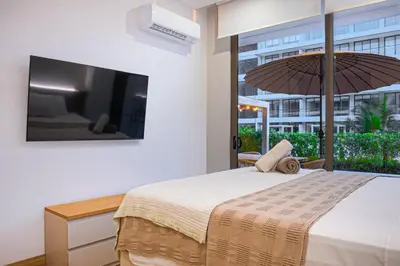 a bedroom with a bed with an umbrella and a tv at Deluxe en MorrosEos con piscina privada y salida a la playa in Cartagena de Indias