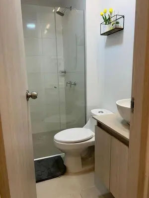 a bathroom with a toilet and a glass shower at Vicmag House Barranquilla in Barranquilla