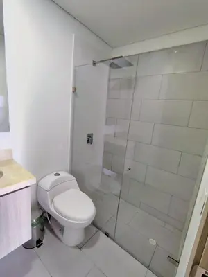 a white bathroom with a toilet and a shower at Apartamento en Edificio Magno Loft Apto DP 1001 in Cartagena de Indias