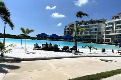 a resort with a beach with chairs and a pool at Baia Kristal: descanso, vista y naturaleza única in Los Arrayanes
