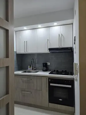 a kitchen with white cabinets and a sink and a stove at Apartamento Cerca al Mar Cartagena in Cartagena de Indias