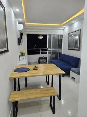 a living room with a table and a blue couch at Apartamento Cerca al Mar Cartagena in Cartagena de Indias
