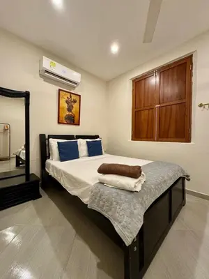 a bedroom with a large bed with a wooden cabinet at Casa Stephanie - Getsemani - Private pool in Cartagena de Indias