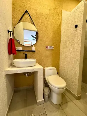 a bathroom with a toilet and a sink and a mirror at Casa Salvatore - Getsemani - Private pool in Cartagena de Indias