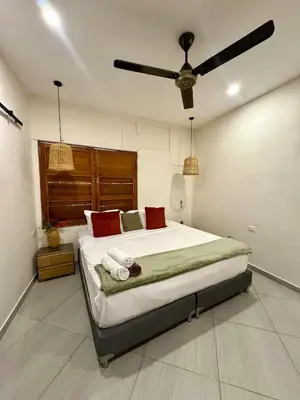 a bedroom with a large bed with a ceiling fan at Casa Salvatore - Getsemani - Private pool in Cartagena de Indias