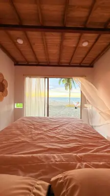 a bedroom with a bed with a view of the beach at Casa jaguar frente al mar in San Bernardo del Viento