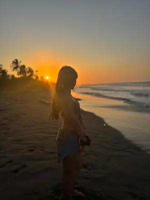 a woman standing on the beach at sunset at Casa jaguar frente al mar in San Bernardo del Viento