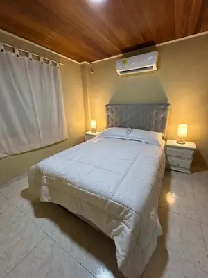 a bedroom with a large white bed with two lamps at Apartamento Barrio San Jose Barranquilla in Barranquilla