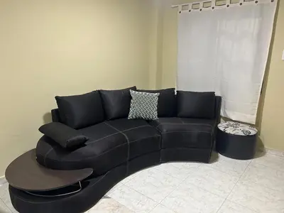 a black leather couch in a living room at Apartamento Barrio San Jose Barranquilla in Barranquilla