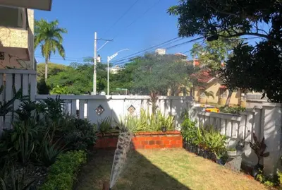 a backyard with a white fence and some plants at Alto prado 75 house in Barranquilla