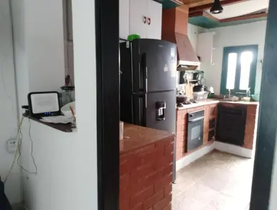 a kitchen with a refrigerator and a laptop on a counter at Alto prado 75 house in Barranquilla