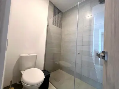 a bathroom with a toilet and a glass shower at Apartamento familiar en Santa Marta con vista al mar y la Sierra in Santa Marta