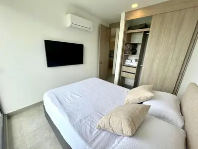 a bedroom with a bed and a tv on the wall at Apartamento familiar en Santa Marta con vista al mar y la Sierra in Santa Marta