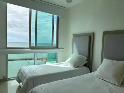 two beds in a room with a view of the ocean at Apartamento con vistas al Mar caribe in Coveñas