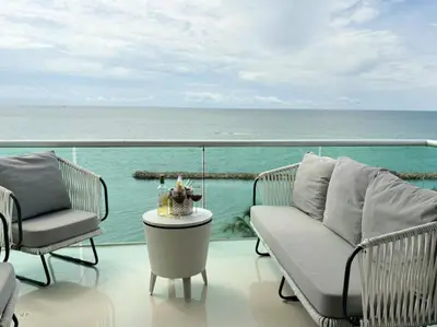 a balcony with chairs and a table and the ocean at Apartamento con vistas al Mar caribe in Coveñas