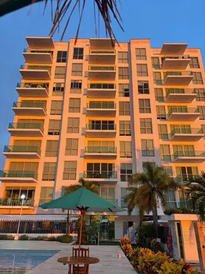 a large apartment building with a table and an umbrella at Apartamento con vistas al Mar caribe in Coveñas