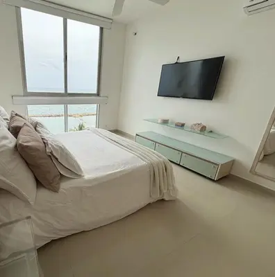 a bedroom with a bed and a flat screen tv at Apartamento con vistas al Mar caribe in Coveñas