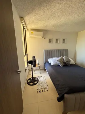 a small bedroom with a bed and a lamp at Corazón de quilla in Barranquilla