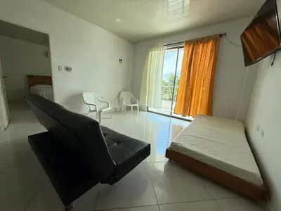 a bedroom with a bed and a chair and a window at Apartment 402 Tolú 2 habitaciones in Tolú