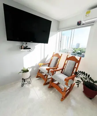 two rocking chairs in a living room with a flat screen tv at Beach Nearby Stunning Views Ultimate Comfort in Cartagena de Indias