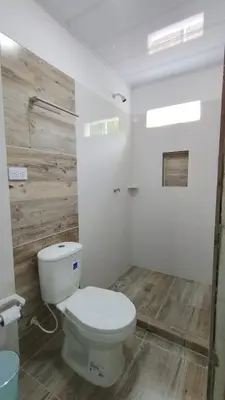 a bathroom with a white toilet and a wooden floor at MiraMar in Guayabal