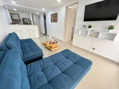 a living room with a blue couch and a tv at Ocean Drive Cartagena Apto con Piscina Infinity in Cartagena de Indias