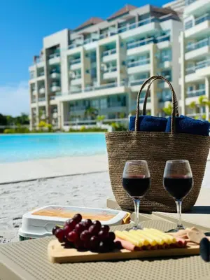a table with two glasses of wine and a plate of food at Baia Kristal Top Floor-Elegance and Luxury View in Los Arrayanes