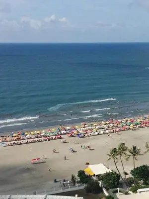a beach with many umbrellas and people on the beach at Large and beautiful Oceanfront Penthouse in Cartagena de Indias