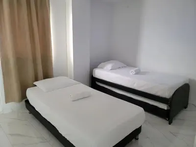 two twin beds in a room with white walls at Large and beautiful Oceanfront Penthouse in Cartagena de Indias