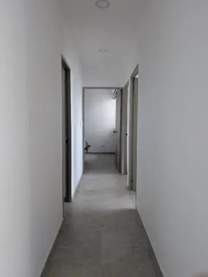 a corridor of an empty room with white walls and doors at Apartamento amoblado en Cartagena cerca a la playa in Cartagena de Indias