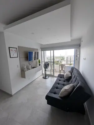 a living room with a black couch and a table at Apartamento amoblado en Cartagena cerca a la playa in Cartagena de Indias