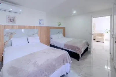 a bedroom with two beds and a couch at Spacious beachfront apartment in Cartagena de Indias