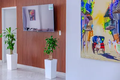 two potted plants in a room with a painting at Spacious beachfront apartment in Cartagena de Indias