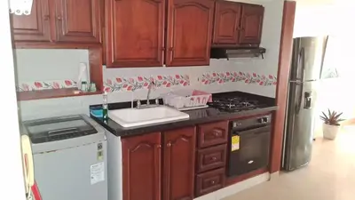 a kitchen with wooden cabinets and a sink and a stove at apartamento en marbella dúplex, cerca centro histórico - 3 in Cartagena de Indias
