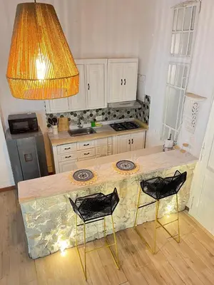 a kitchen with a counter with two chairs and a light at Apartamento Cartagena - centro histórico in Cartagena de Indias
