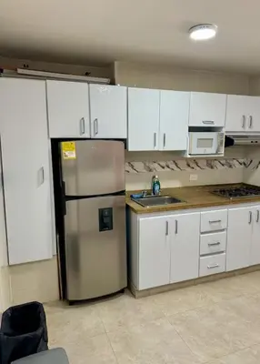 a kitchen with a stainless steel refrigerator and white cabinets at leslies apartamentos in Cartagena de Indias